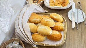 A buffet table with various food items, including bread, pastries, and a pizza. - Chalés Casa Rosa (Alto Paraíso de Goiás)