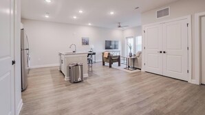 A spacious living area with a kitchen island, a dining table, and a seating area. - Landing | Stunning 1BD, Pool (Tice)