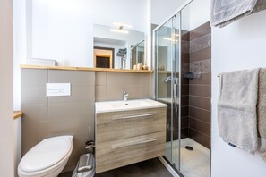 A modern bathroom with a glass shower enclosure, a white sink, and a wooden vanity. - “Chenin” Guest Room with Wi-Fi (Sèvremont)