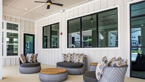 A modern lounge area with round seating and large windows. - Landing | Beautiful 2BD, Gym, Pool (Ocala)