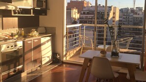 Eine moderne Küche mit Edelstahlgeräten und einer Essecke mit Blick auf die Stadt.