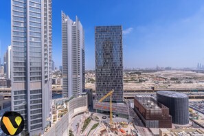 A modern urban skyline with high-rise buildings, a construction site, and a clear blue sky. - Downtown near Dubai Mall Burj Khalifa (Dubai)