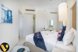 A hotel room with a bed, a desk, a chair, a mirror, and a painting on the wall. - Downtown near Dubai Mall Burj Khalifa (Dubai)