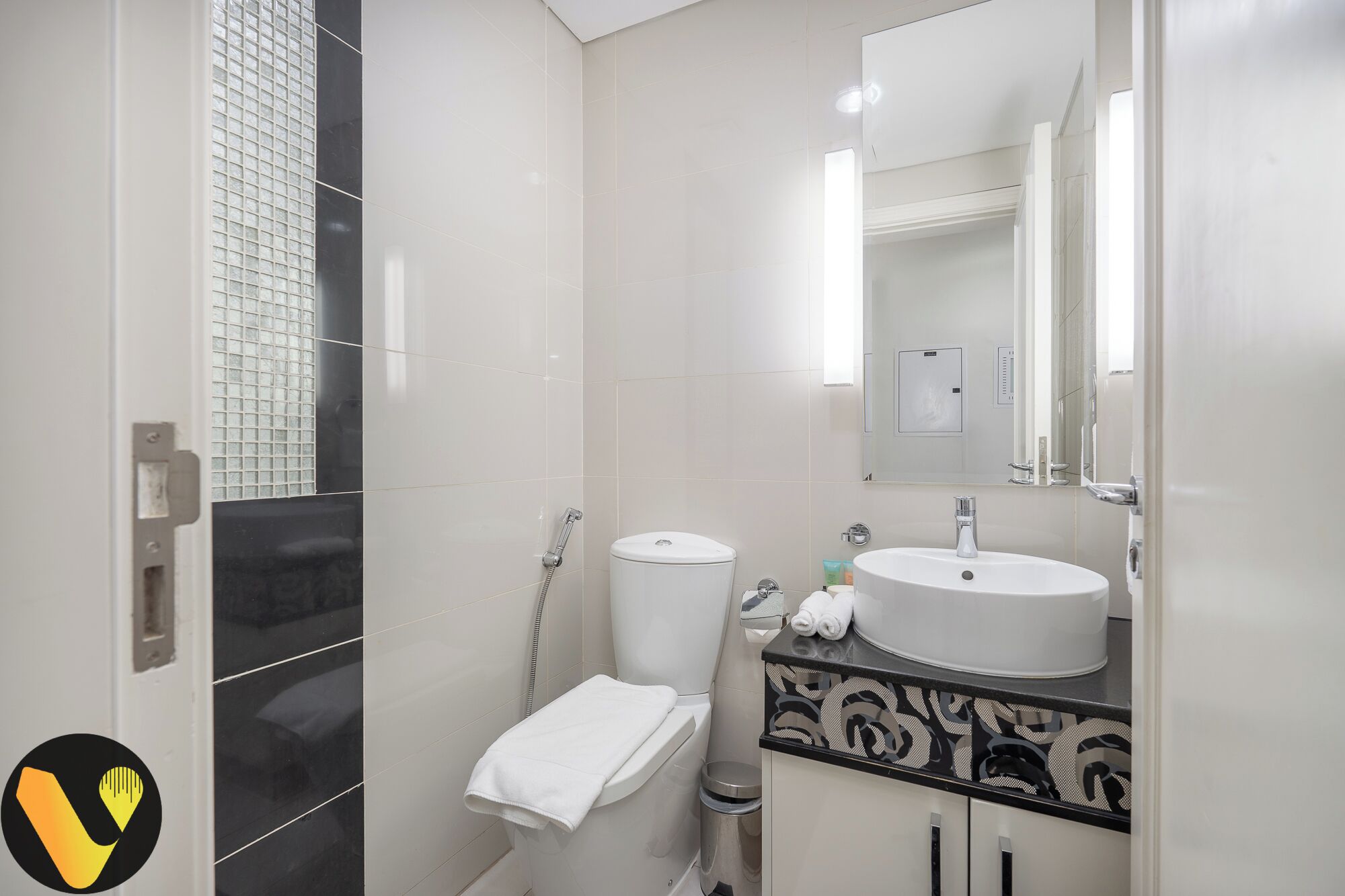 Une salle de bain moderne équipée de toilettes, d’un lavabo et d’une douche.