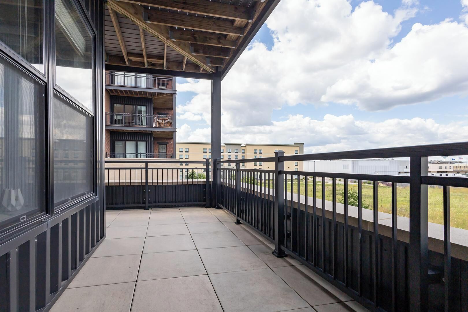 A balcony with a view of a building and a clear sky.