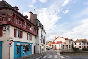 A street with buildings, a blue storefront, and a sign for the Musée du Sel. - Clara Panoramic Terrace T2 Apartment with Wi-Fi (Salies-de-Béarn)