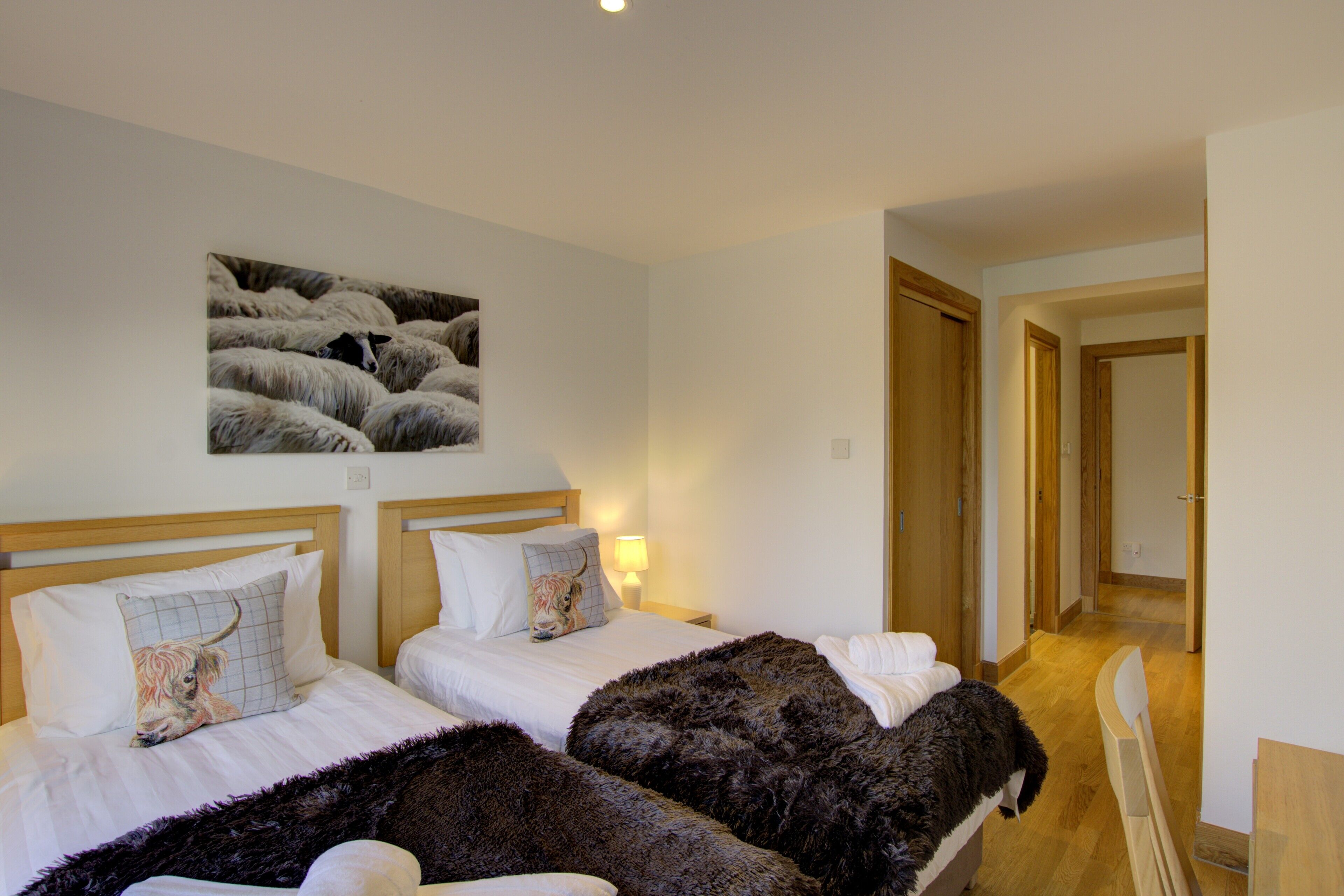Ein Hotelzimmer mit zwei Betten, einem großen Wandbild und Holzboden.