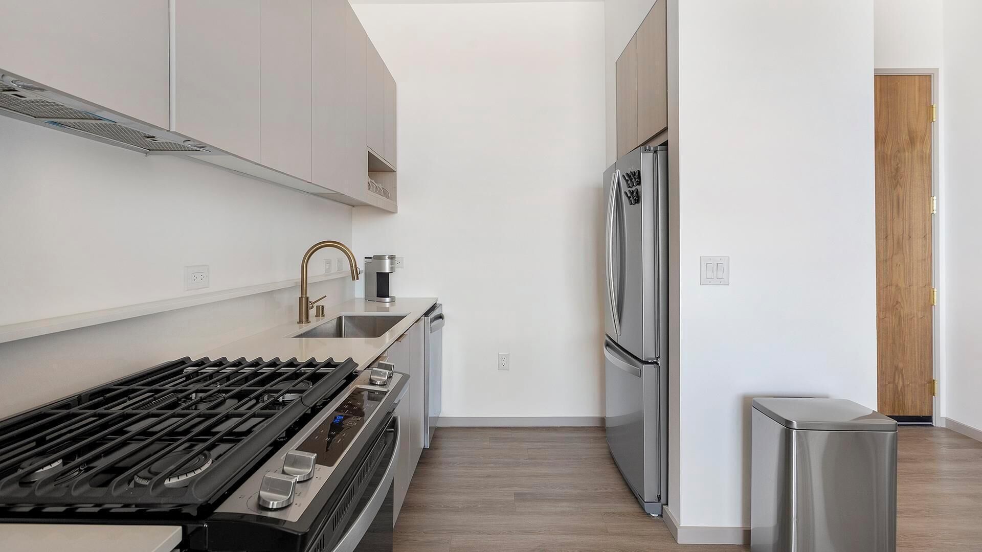 A modern kitchen with stainless steel appliances, a gas stove, and a refrigerator.