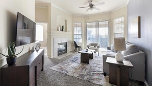 Ein Wohnzimmer mit Kamin, Fernseher und einer Couch.