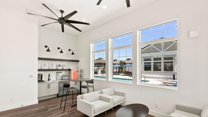 A spacious living area with a kitchen, large windows, and a ceiling fan. - Landing | Stylish 1BD, Gym (Phoenix)