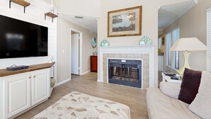 Una sala de estar con chimenea, televisor y sofá.
