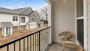 A balcony with a view of a residential area, including houses and a small building. - Landing | Stunning 1BD, Clubhouse, Gym (Madison)