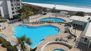 Ein Resort mit großem Pool, Blick auf den Strand und mehreren Liegebereichen.
