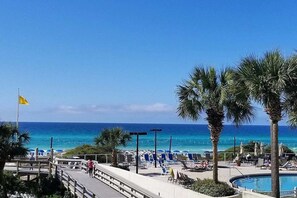 A poolside area with lounge chairs and a flag. - Private beach access, tennis retreat, 8 guests (Miramar Beach)