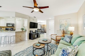 A modern kitchen with a microwave, stove, and dining area. There is a ceiling fan, a TV, and a seating area with a sofa and a coffee table. - Beach access + resort amenities at TOPS'L (Miramar Beach)