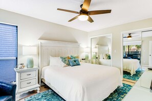 A bedroom with a large bed, a ceiling fan, a nightstand with a lamp, a dresser, and a mirror. - Beach access + resort amenities at TOPS'L (Miramar Beach)