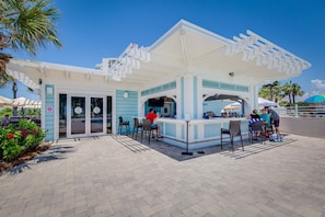 A beachside kiosk with a white and blue color scheme, outdoor seating, and a sheltered area. - Beach access + resort amenities at TOPS'L (Miramar Beach)