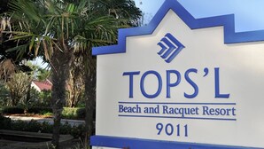 Letrero del TOPS'L Beach and Racquet Resort con el número 9011.