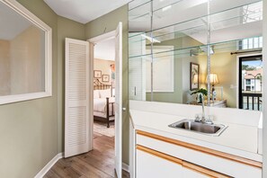 A kitchen with a sink, a glass door leading to a bedroom, and a hallway with wooden flooring. - 2BR villa: steps to beach & tennis courts (Miramar Beach)