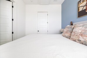 Ein Schlafzimmer mit einem Bett, einer weißen Tür und einer blauen Wand.