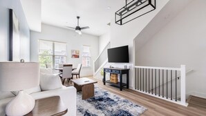 A modern living room with a sofa, coffee table, and a TV on a stand. - Landing | Modern 2BD in Lee's Summit (Lee's Summit)