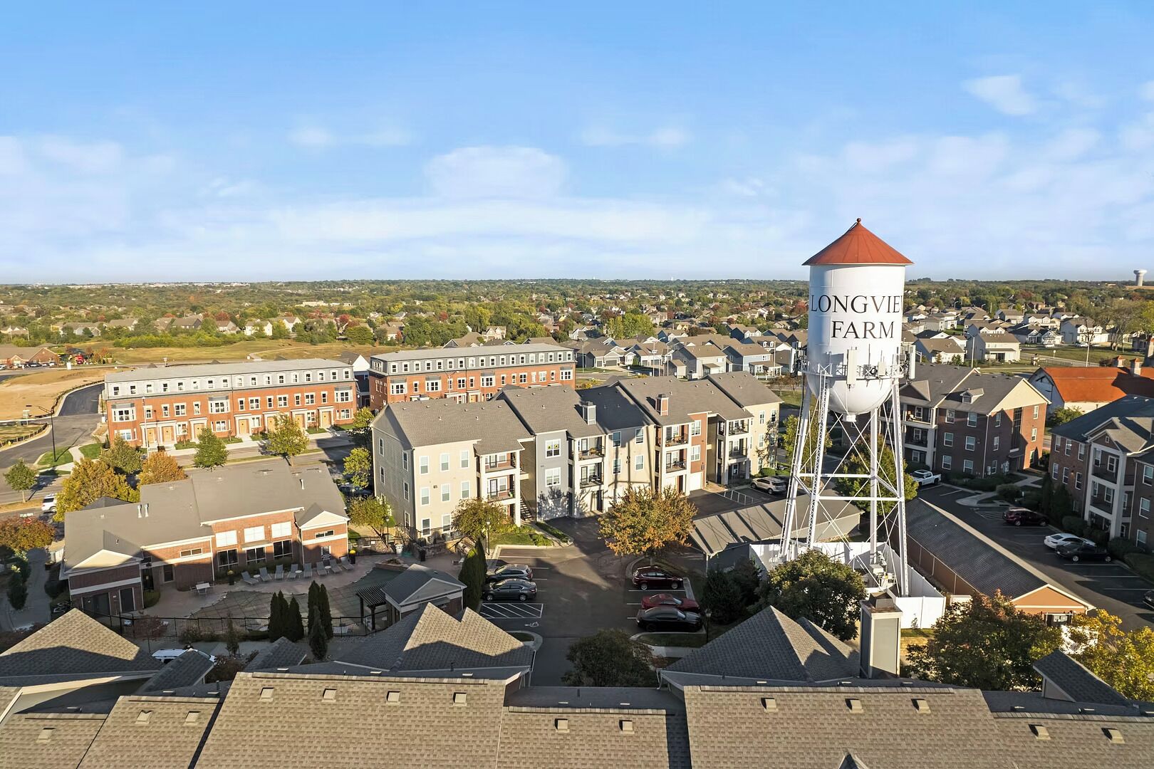 A residential area with a prominent water tower labeled "LONGVIE FARM" and several multi-story buildings with a mix of brick and modern architecture.