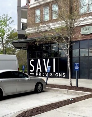 A building with a sign reading "SAVI PROVISIONS" and a parked car in front. - 1B and 1B - Luxury Comfort apartment in  Atlanta with AC and fitness room (Atlanta)