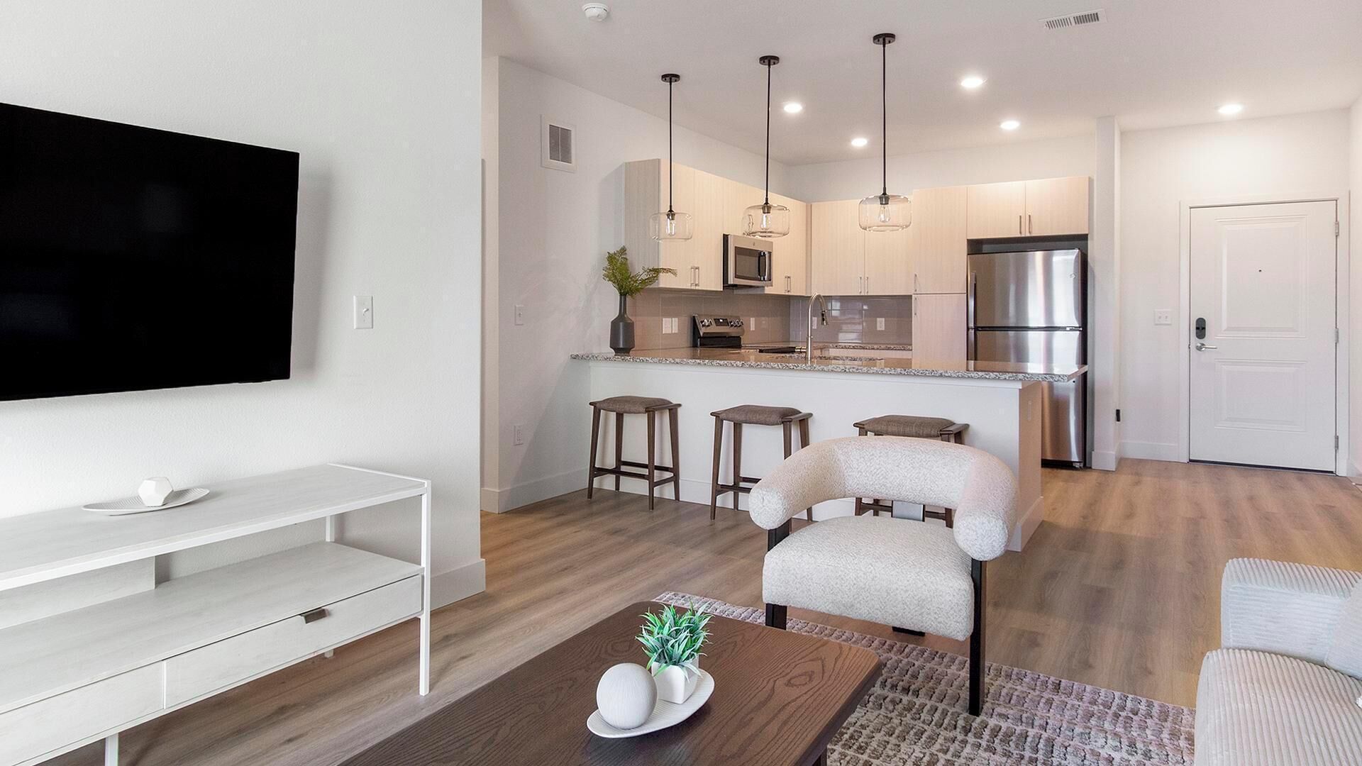 Un appartement moderne comprenant un salon, une cuisine et un coin repas.