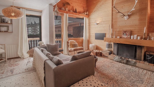 Interior acogedor de una cabaña de troncos con un sofá, sillones, una chimenea y una decoración con cráneo de venado.