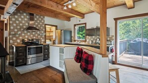 A modern kitchen with a large island, stainless steel appliances, and a view of the outdoors.