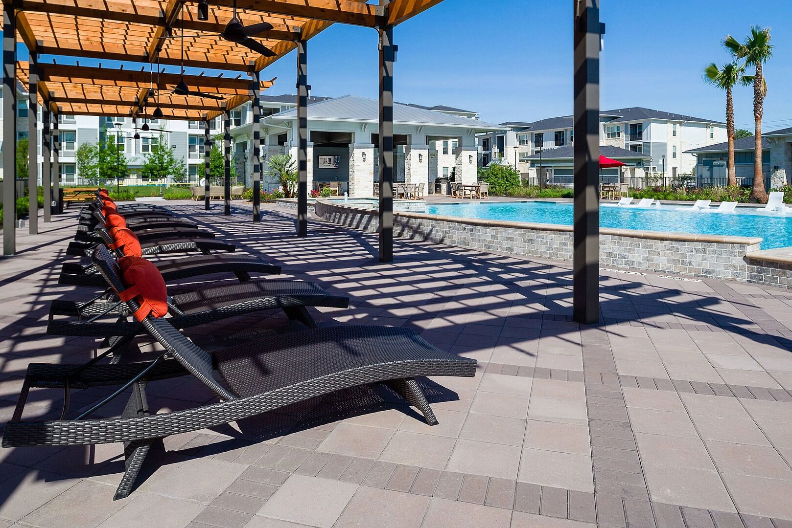 Un espace aménagé au bord de la piscine, avec des chaises longues et un coin salon abrité.