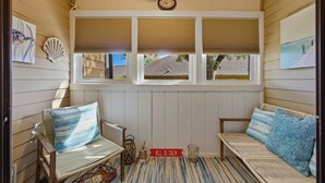 A cozy room with a window, two chairs, a bench, and a clock on the wall. - ☀️Great Location | Walk to Beach | Heron Pointe B-8☀️ (Myrtle Beach)