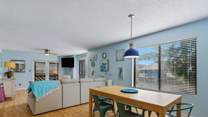 A compact living space with a dining area, a sofa, a TV, and artwork on the walls. - ☀️Great Location | Walk to Beach | Heron Pointe B-8☀️ (Myrtle Beach)