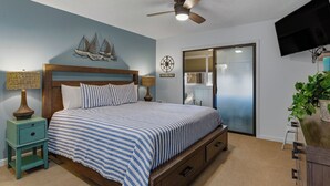 A bedroom with a bed, a ceiling fan, a television, a window, and a plant. - ☀️Great Location | Walk to Beach | Heron Pointe B-8☀️ (Myrtle Beach)