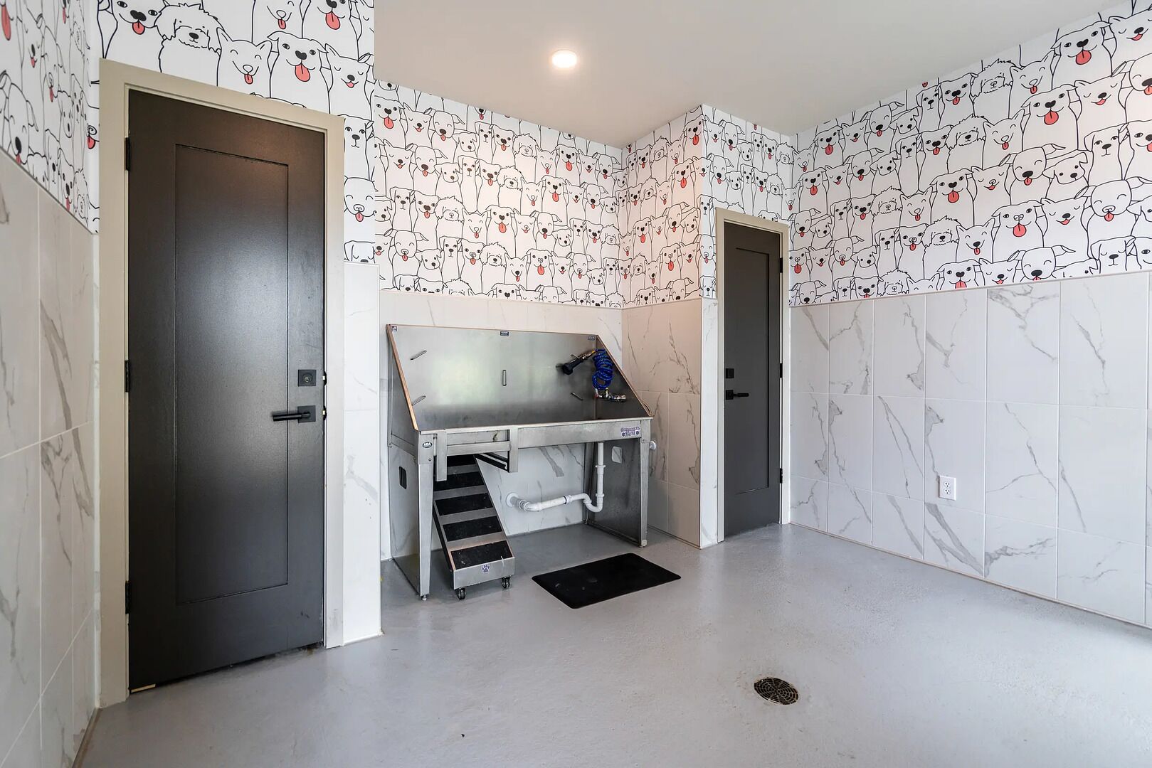 A room with a kitchenette, a door, and a patterned wall.