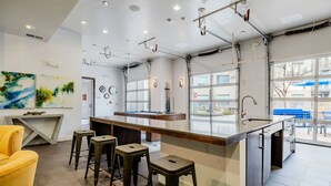 Una cocina moderna con barra, taburetes y vistas al exterior.