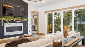 Una sala de estar moderna con chimenea, ventanas amplias y una zona de estar acogedora.