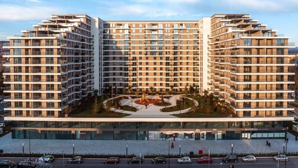 A multi-story hotel with a central courtyard, multiple balconies, and a modern architectural design.