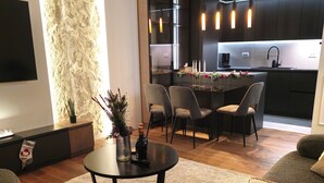 A modern living room with a round coffee table, a sofa, and a dining area with chairs.