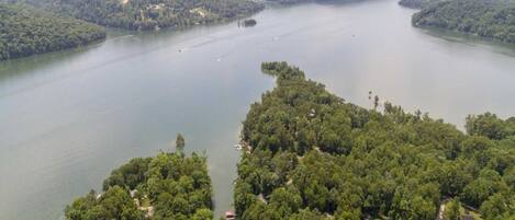 An aerial view of a lake surrounded by dense forest and hills.