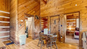 A wooden cabin interior with a dining area, a bathroom, and a bedroom. - 1 mile from Historic Townsend・Hot Tub・Fireplace (Townsend)