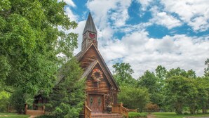 A wooden cabin with a steeply pitched roof, a decorative heart-shaped window, and a small porch with steps leading to the entrance. - 1 mile from Historic Townsend・Hot Tub・Fireplace (Townsend)