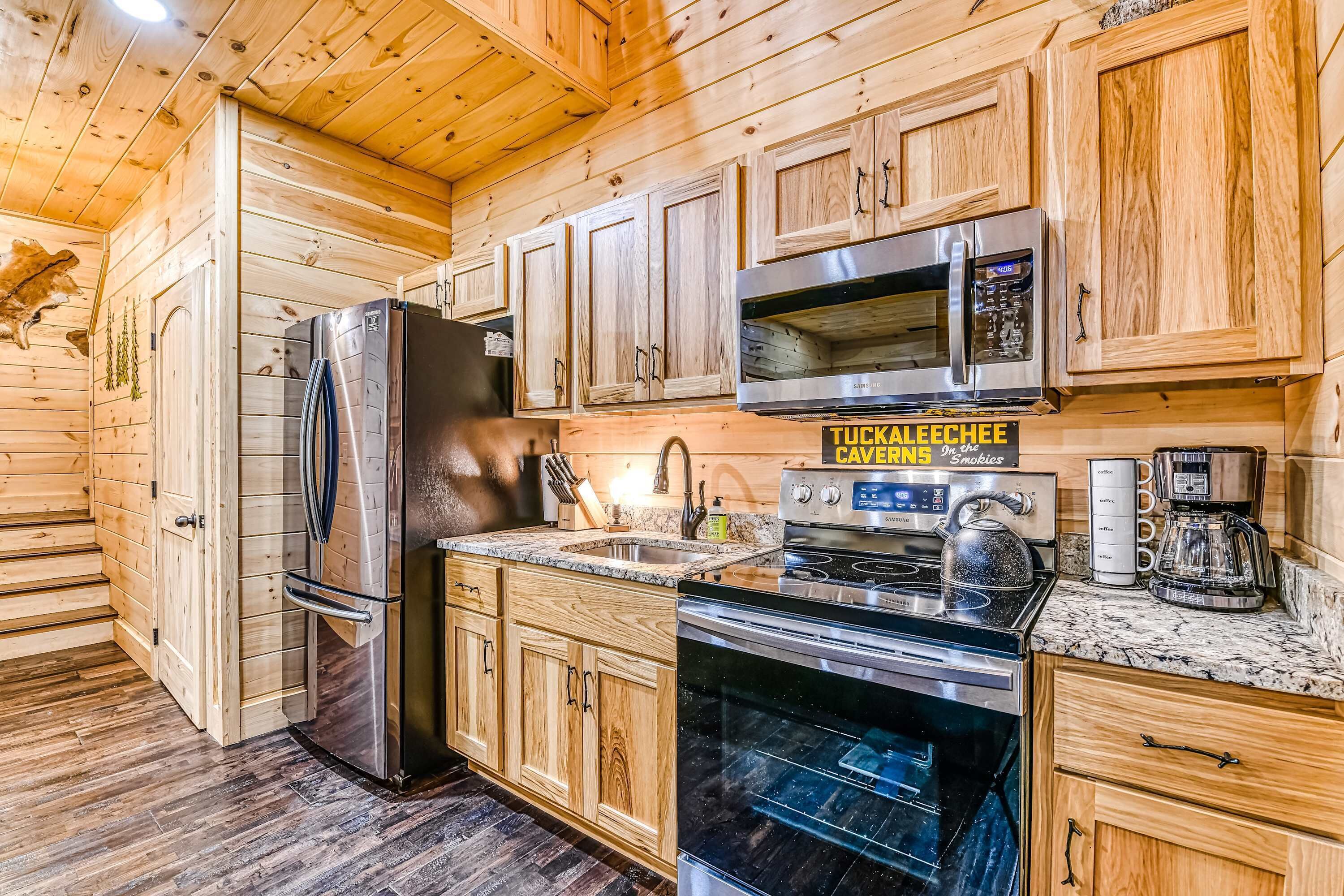A modern kitchen with wooden cabinets, stainless steel appliances, and a sign reading "TUCKALEE CAVERNS".