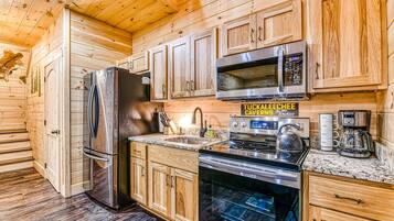 A modern kitchen with wooden cabinets, stainless steel appliances, and a sign reading "TUCKALEE CAVERNS".