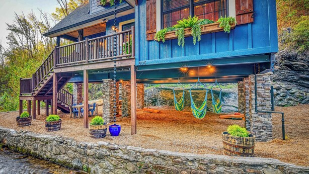 A blue house with a wooden deck, outdoor seating, and hanging hammocks. - Creekside Luxury Cabin, Hot Tub, Near Downtown (Gatlinburg)