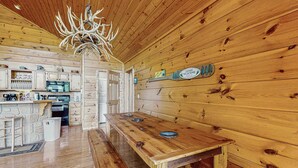 Ein Holzinnenraum mit einer Holzbank, einer Chandelüster und einem Willkommensschild.
