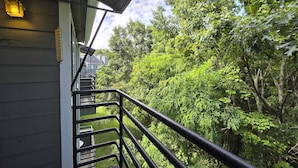A staircase leading to a balcony with a view of dense greenery. - Gatlinburg Condo, for 6・Pools・Hot Tub・Lovely Views (Gatlinburg)
