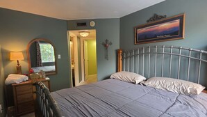 A bedroom with a bed, a dresser, a mirror, a radiator, and a framed picture on the wall. - Gatlinburg Condo, for 6・Pools・Hot Tub・Lovely Views (Gatlinburg)