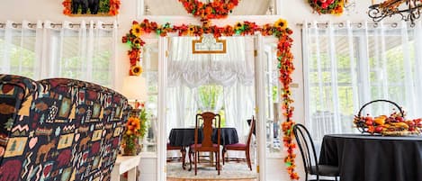 Une pièce chaleureuse avec un canapé à motifs, une table à manger avec des chaises et un lustre.