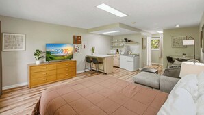 A modern hotel room with a bed, a TV, a kitchenette, and a dining area. - Relaxing Studio, Sleeps 2, Near Golf & Douglas Lake (Baneberry)
